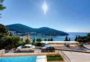 a group of cars parked in a parking lot next to the water at Villa Katarina 2nd Floor Apartments in Dubrovnik