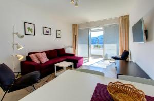 a living room with a red couch and a table at Villa Katarina 2nd Floor Apartments in Dubrovnik
