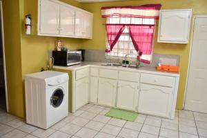 a kitchen with a washing machine and a sink at Aanola Villas A4 Spacious Caribbean Casa in Charlotte