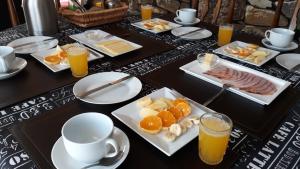 stół z talerzami śniadaniowymi i sokiem pomarańczowym w obiekcie Alojamiento Los Nogales w mieście Rancagua