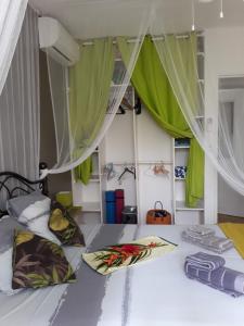 una camera da letto con un letto con tende verdi di chambre et table d’hôte au Diamant a Le Diamant