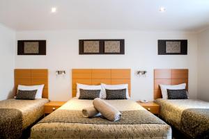 a bedroom with two beds and two pillows at Tea House Motor Inn in Bendigo +112 photos