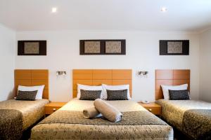 a bedroom with two beds and two pillows at Tea House Motor Inn in Bendigo