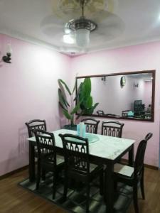 a dining room with a table and chairs and a mirror at Homestay Temerloh Jaya in Temerloh