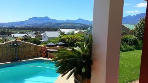 a view of a swimming pool with mountains in the background at Helderberg Guesthouse in Gordonʼs Bay