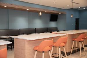 a conference room with orange chairs and tables at Holiday Inn & Suites - Fayetteville W-Fort Bragg Area, an IHG Hotel in Fayetteville