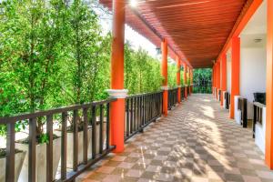 a corridor of a house with orange columns and trees at Palm Beach Resort in Pran Buri