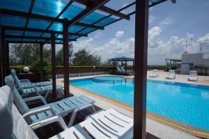 a swimming pool with white lounge chairs next to a swimming pool at Avatara A Ocean Views by malai in Ban Tha Fat