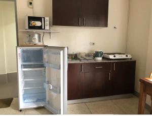 een keuken met een open koelkast en een deur open bij 500Mbps Wi-Fi 2-Story Apartments in Cebu City