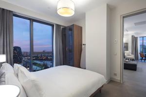 a bedroom with a white bed and a large window at RETRO 9 HOMES & SUITES ISTANBUL in Istanbul