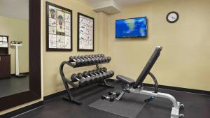 a fitness room with a bench and a clock at Holiday Inn Express & Suites Naples Downtown - 5th Avenue by IHG in Naples