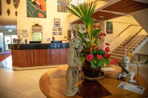 a lobby with figurines on a table with flowers at Bird Of Paradise Hotel in Goroka