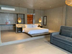Tabuelan的住宿－Cebu R Resort Tabuelan，一间卧室配有一张床、一张沙发和一把椅子