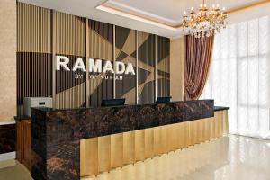 a lobby of a rambala hotel with a reception desk at Ramada by Wyndham Shymkent in Shymkent