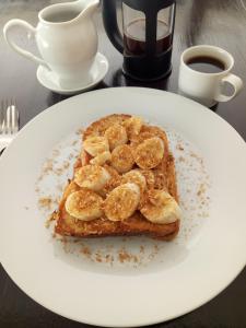 a white plate with a piece of toast with bananas on it at JJ's Hostel Mirissa in Mirissa