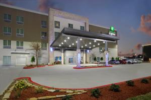 a hotel parking lot with a gas station with lights at Holiday Inn Express & Suites - Lake Charles South Casino Area, an IHG Hotel in Lake Charles