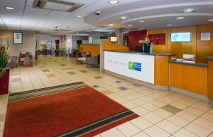 a man standing at a counter in a lobby at Holiday Inn Express Droitwich Spa, an IHG Hotel in Droitwich