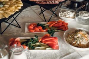a table with plates of vegetables and other foods at Kamelot in Ternopil