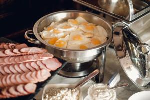 a pot of eggs and sausages on a table at Kamelot in Ternopil +61 photos