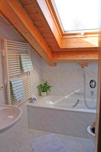 een badkamer met een bad en een wastafel bij Ferienhaus am Römerweg in Klais