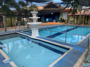 a swimming pool with a fountain in the middle at Rufina's Leisure Center in Tagum