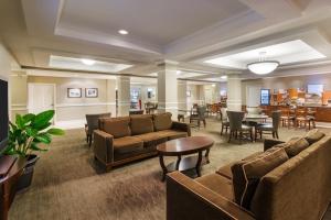 a lobby with couches and tables and a dining room at Holiday Inn Express Hotel & Suites New Iberia - Avery Island, an IHG Hotel in New Iberia