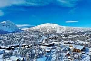 a town covered in snow with a mountain in the background at Hovdestøylen in Hovden