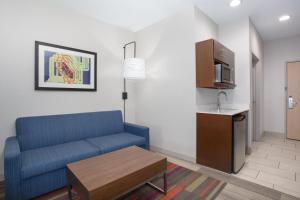 阿馬里洛的住宿－Holiday Inn Express & Suites Amarillo, an IHG Hotel，一间带蓝色沙发的客厅和一间厨房