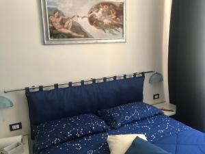 un letto blu in una camera da letto con un dipinto sul muro di DA GIANNI E BEA a Foligno