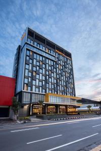 a large hotel building with a road in front of it at PORTA by Ambarrukmo in Yogyakarta