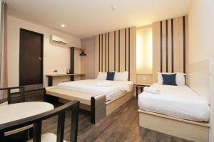 a hotel room with two beds and a table at Grand Kapar Hotel Klang Sentral in Klang