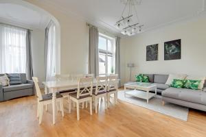 a living room with a table and a couch at Lion Apartments - Palermo Spacious Family Apartment 3 min walk from the beach in Sopot