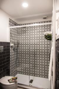 a bathroom with a toilet and a glass shower at Ad Hoc Rooms in Palermo