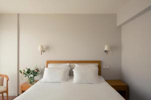 a bedroom with a white bed with white pillows at Cabo Verde Hotel in Mati