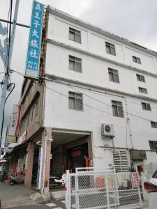 a white building on the corner of a street at Zhen Wang Zi Hotel in Chenggong