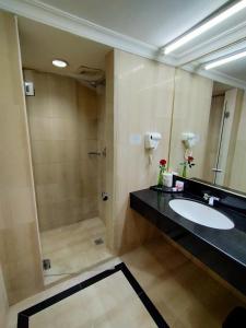 a bathroom with a sink and a shower at Tang Dynasty Hotel in Kota Kinabalu