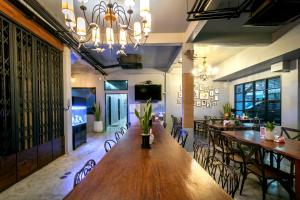 a dining room with a long wooden table and chairs at Castle Black Bangkok in Bangkok