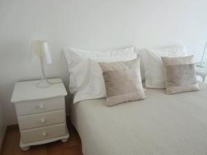 ポンタ・デルガダにあるLucy´s Apartmentのベッド(白い枕、ナイトスタンドのランプ付)