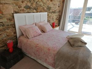 a bedroom with a bed with a brick wall at Belge'attitude Maison d'hôtes in Commequiers