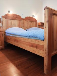 Cama grande de madera en habitación con suelo de madera en Apartments Povh, en Ljubno