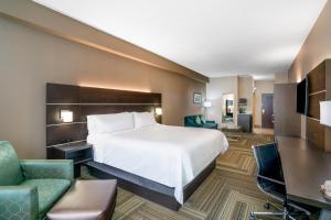 a hotel room with a bed and a desk and chairs at Holiday Inn Express Hotel & Suites Ashland, an IHG Hotel in Ashland