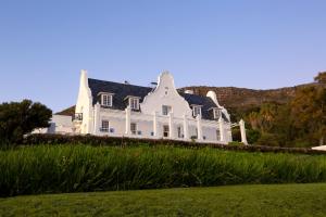 a large white house with a black roof at Stillness Manor Estate & Spa in Constantia