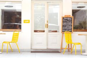 two chairs sitting outside of a restaurant with a chalkboard at Bloomrooms @ Link Road in New Delhi