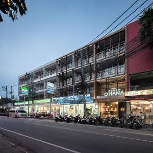 a building with motorcycles parked in front of a street at Sugar Ohana Poshtel in Kata Beach