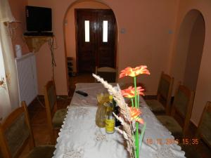 ein Esstisch mit weißer Tischdecke und Blumen in der Unterkunft Cabana Larisa in Cavnic