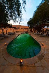 une piscine d'eau verte au milieu dans l'établissement Thousand Nights Camp, à Shāhiq