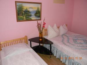 ein Schlafzimmer mit zwei Betten und einem Tisch mit einer Vase mit Blumen in der Unterkunft Cabana Larisa in Cavnic