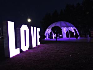 a lit up sign that says love at night at Hotel Texicana in Sulechów