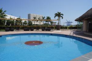 une grande piscine bleue dans un complexe dans l'établissement Holiday Inn Tuxpan - Convention Center, an IHG Hotel, à Tuxpan