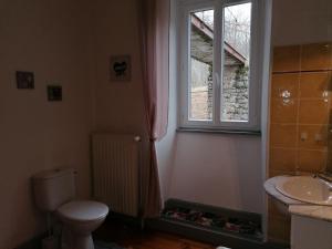 Marcols-les-EauxにあるDomaine de Salomonyのバスルーム(トイレ、洗面台付)、窓が備わります。